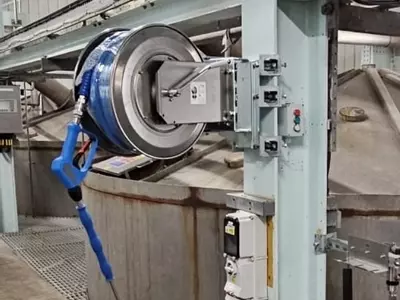 High-pressure stainless steel hose reel and trigger gun mounted to a support column as part of the washdown system at an industrial site in Burton with lance and gun